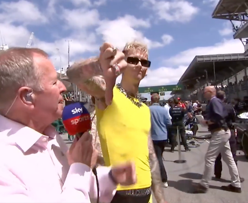 Machine Gun Kelly puts his thumb down to the camera after a bizarre exchange with Martin Brundle in Brazil (Sky F1)