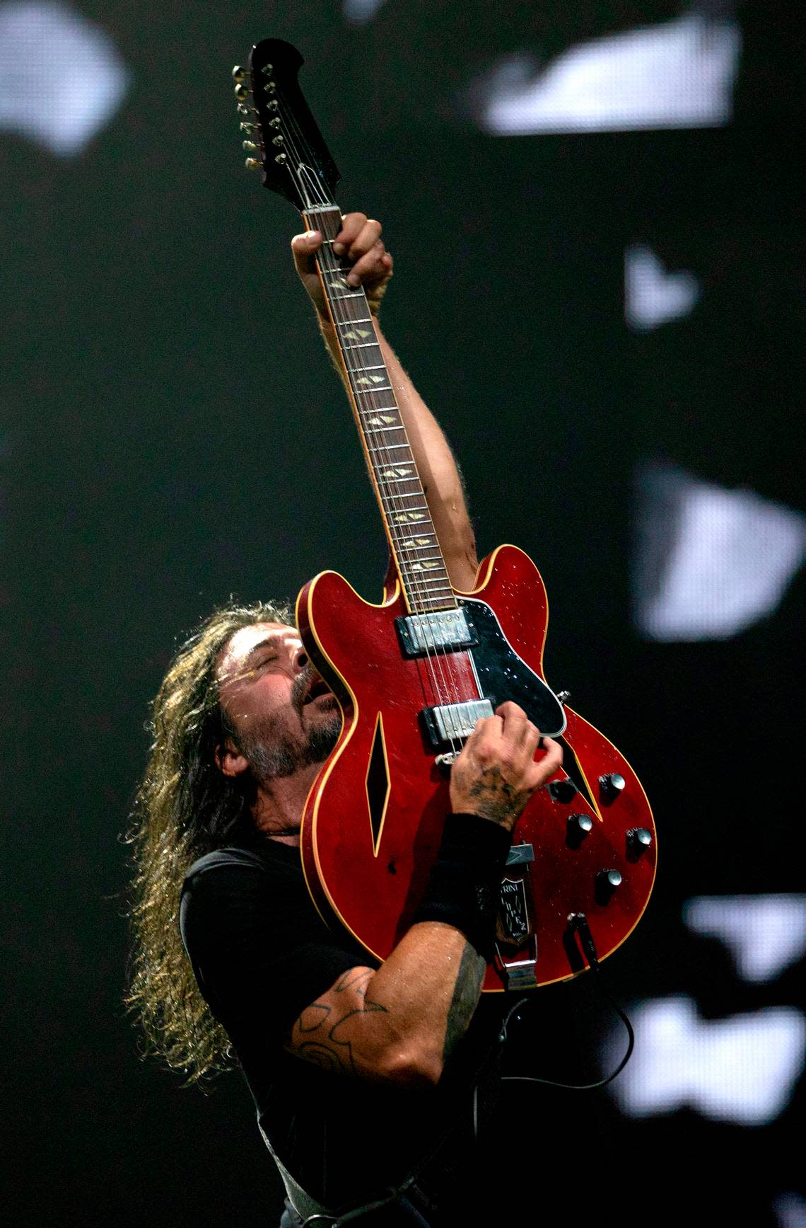 A triumphant Dave Grohl thrusts his guitar into the air as Foo Fighters play Raleigh, N.C.’s Coastal Credit Union Music Park at Walnut Creek, Tuesday night, May 7, 2024. Scott Sharpe/ssharpe@newsobserver.com