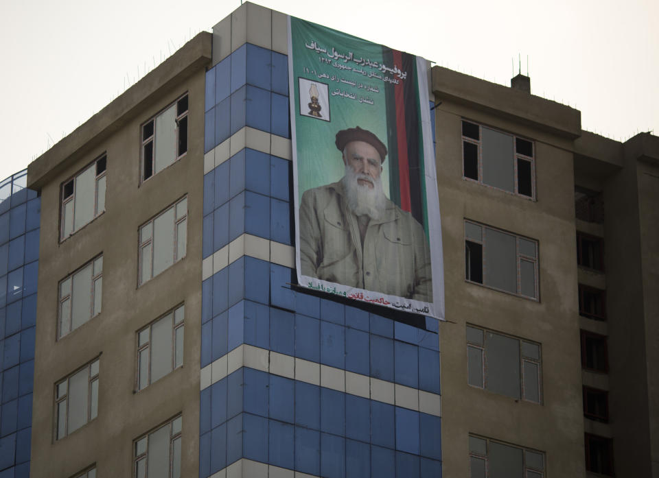 In this Friday, March 7, 2014 photo, an election poster with presidential hopeful Abdul Rasool Sayyaf hangs from a building in Kabul, Afghanistan. Many Afghans accuse Sayyaf of orchestrating mass killing of ethnic Hazaras. Still, many of the candidates or their running mates have violent histories. Several have been named by the U.S.-based Human Rights Watch as responsible for mass killings during the 1992 to 1996 civil war, fought between Islamic insurgents turned warlords who turned their guns on each other after throwing out the invading Soviet military. (AP Photo/Anja Niedringhaus)