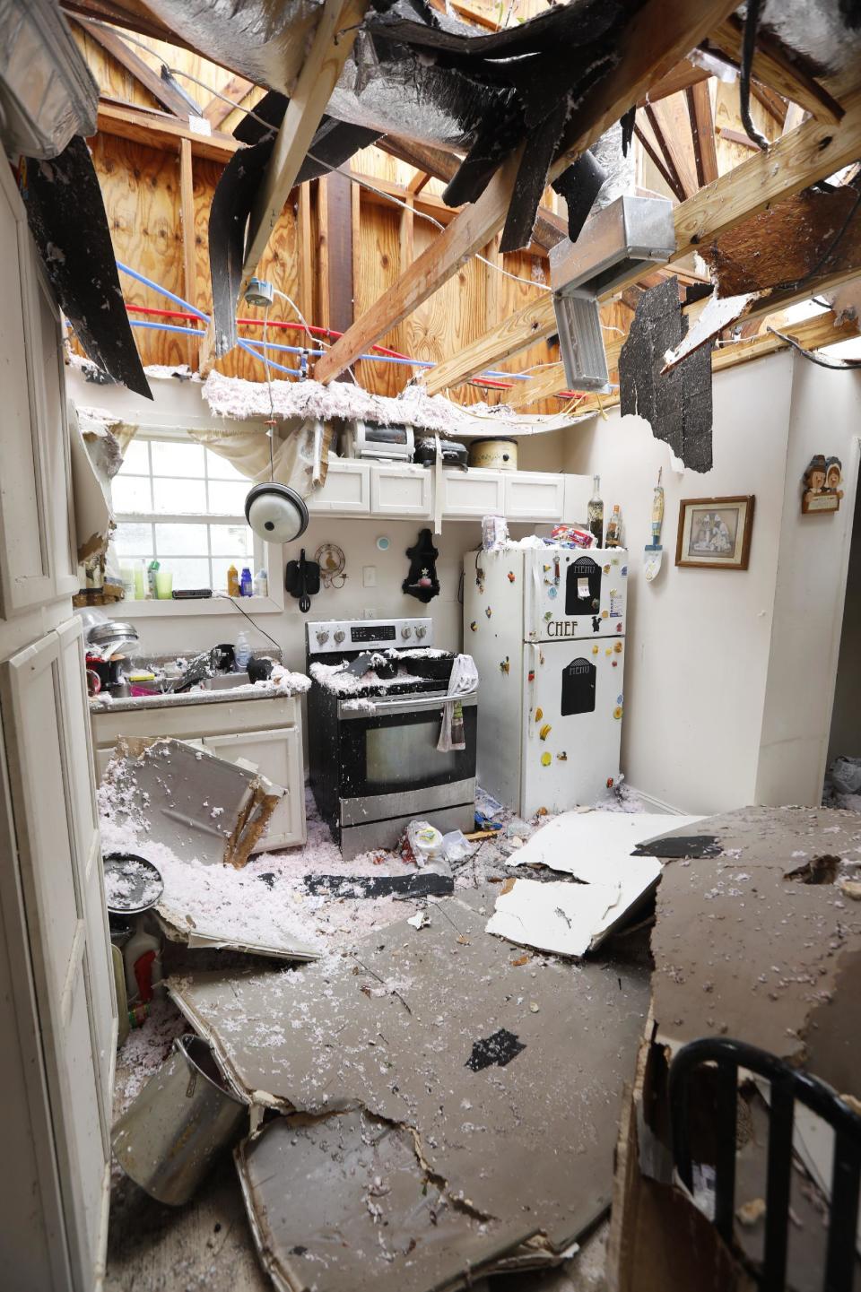 An open kitchen littered with roofing and ceiling debris show the strength of the tornado that hit this south Mississippi community in Hattiesburg, Miss., Saturday, Jan. 21, 2017. The tornado was part of a wall of stormy weather traveling across the region, bringing with it rain and unstable conditions. (AP Photo/Rogelio V. Solis)