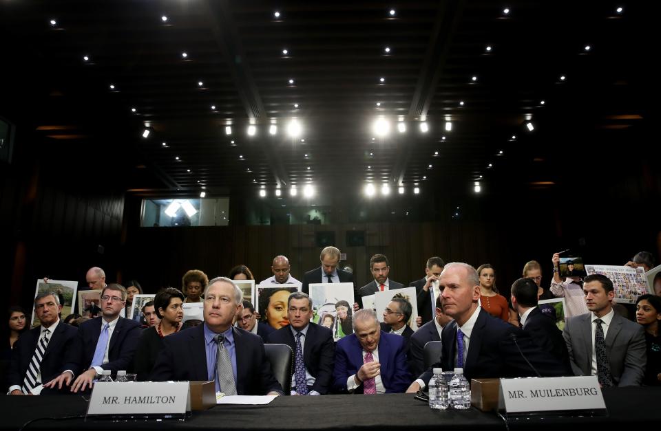 Dennis Muilenburg (R), president and CEO of the Boeing Company, and John Hamilton (L), vice president and chief engineer of Boeing Commercial Airplanes, sit at the witness table in front of family members of those who died aboard Ethiopian Airlines Flight 302 during a hearing held by the Senate Commerce Committee October 29, 2019