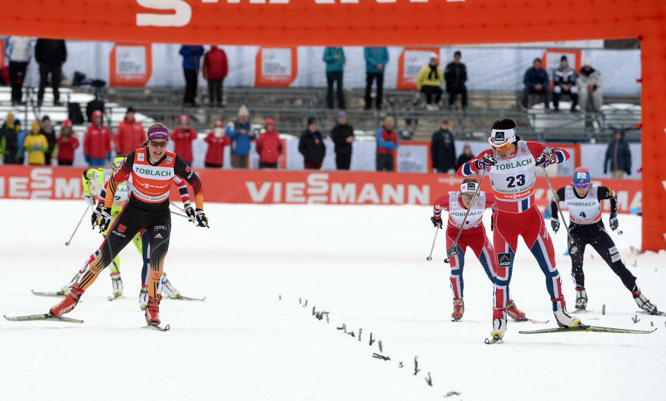 Second placed Herrmann Denise of Germany, left and winner Marit Bjoergen of Norway, sprint to cut the finish line of a cross country women's World Cup sprint, in Dobbiaco, Italy, Sunday, Feb. 2, 2014. (AP Photo/Elvis Piazzi)