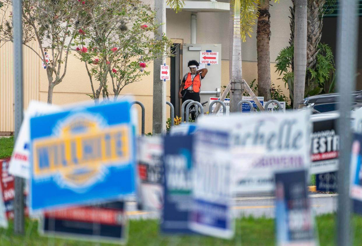 An election deputy waits for more voters during primary day elections at a polling station at the Wellington Branch Library on August 23, 2022 in Wellington, Florida.