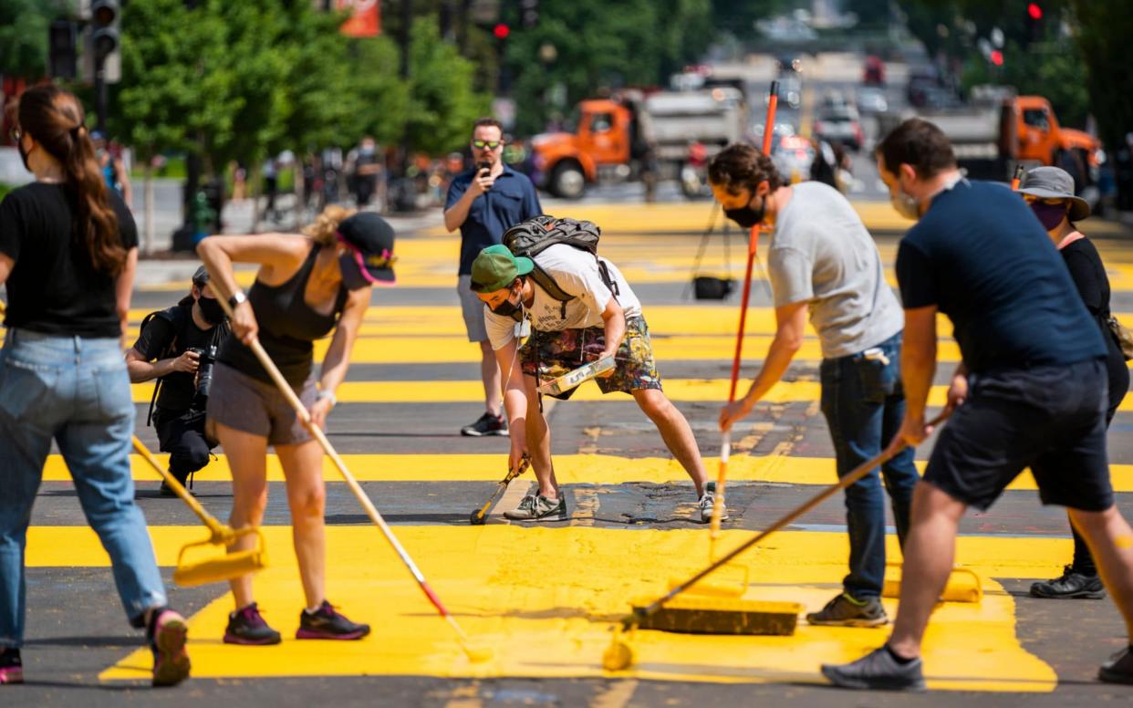 With permission from the city, volunteers paint 'Black Lives Matter' on 16th St. across from the White House, the location of seven days of protests in DC over the death of George Floyd, who died in police custody, in Washington, DC, - Shuttercock