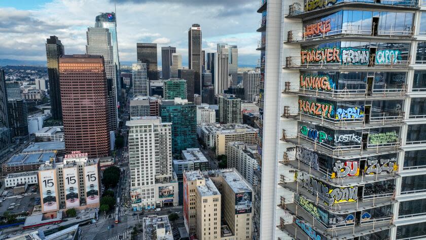 A view of downtown L.A. shows a high-rise covered in colorful graffiti bearing names like KRAZY and FOREVER
