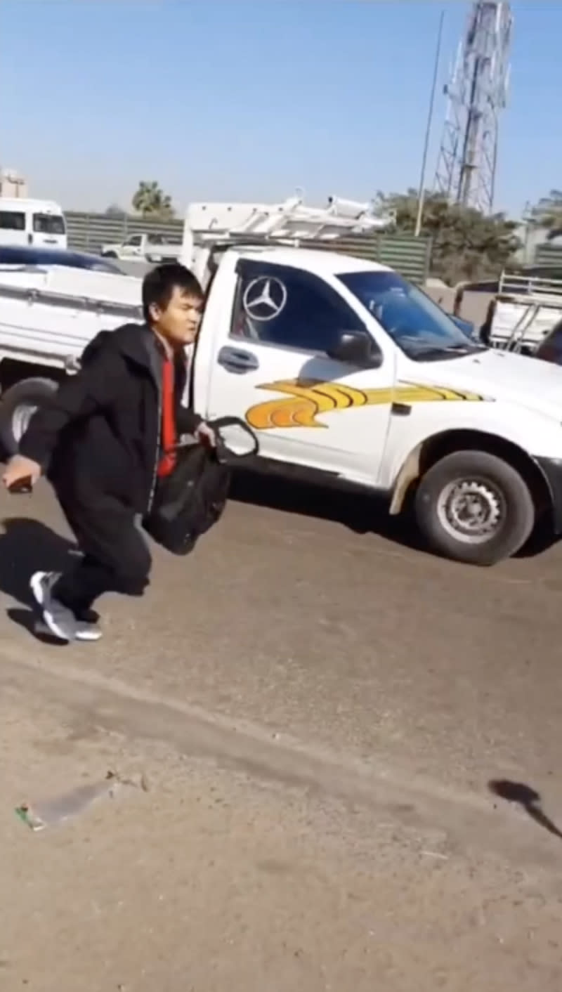 Pictured is a Chinese taxi passenger on a busy ring road next to a ute after he was dumped by his driver. 