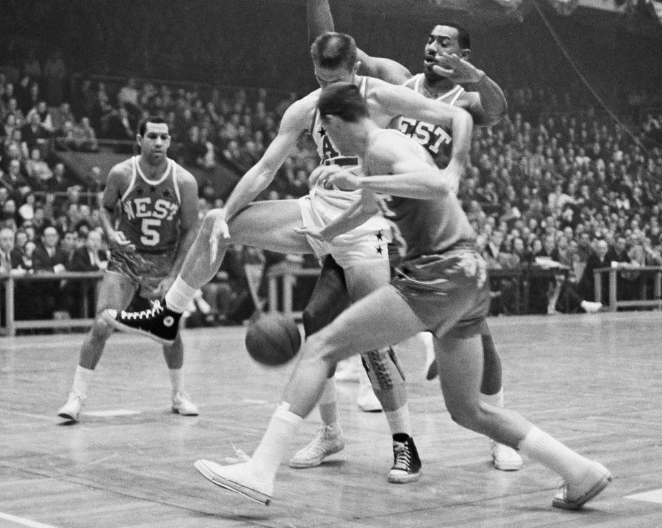 FILE - Terry Dischinger, foreground, of the West, and Tommy Heinsohn, of the East, struggle for a loose ball in the second period of their NBA All-Star game at Boston Garden, Jan. 14, 1964. Also in on the play is Wilt Chamberlain of the West. Looking on at left is Guy Rodgers. (AP Photo/File)