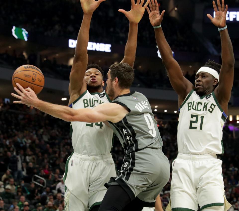 Milwaukee Bucks forward Giannis Antetokounmpo (34) and guard Jrue Holiday defend against Brooklyn Nets guard Goran Dragic during a game last February at Fiserv Forum.