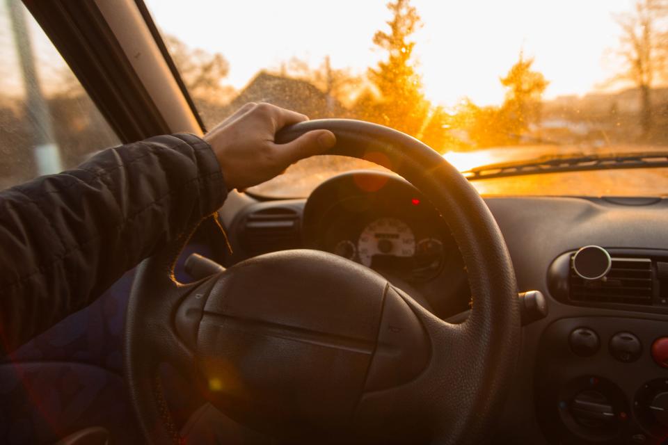 There were allegedly three unrestrained children in the man's back seat. Pictured is a stock image of man with his hand on a steering wheel.