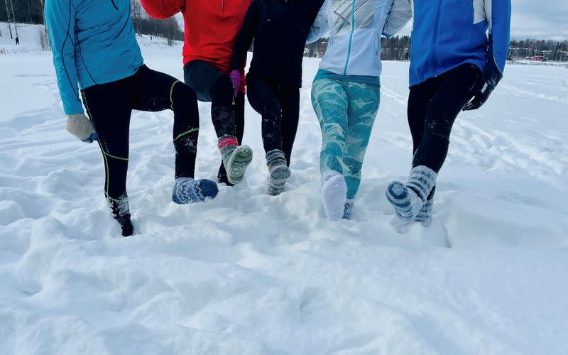 Athletes show woolen socks they are wearing instead of footwear during their training in Espoo