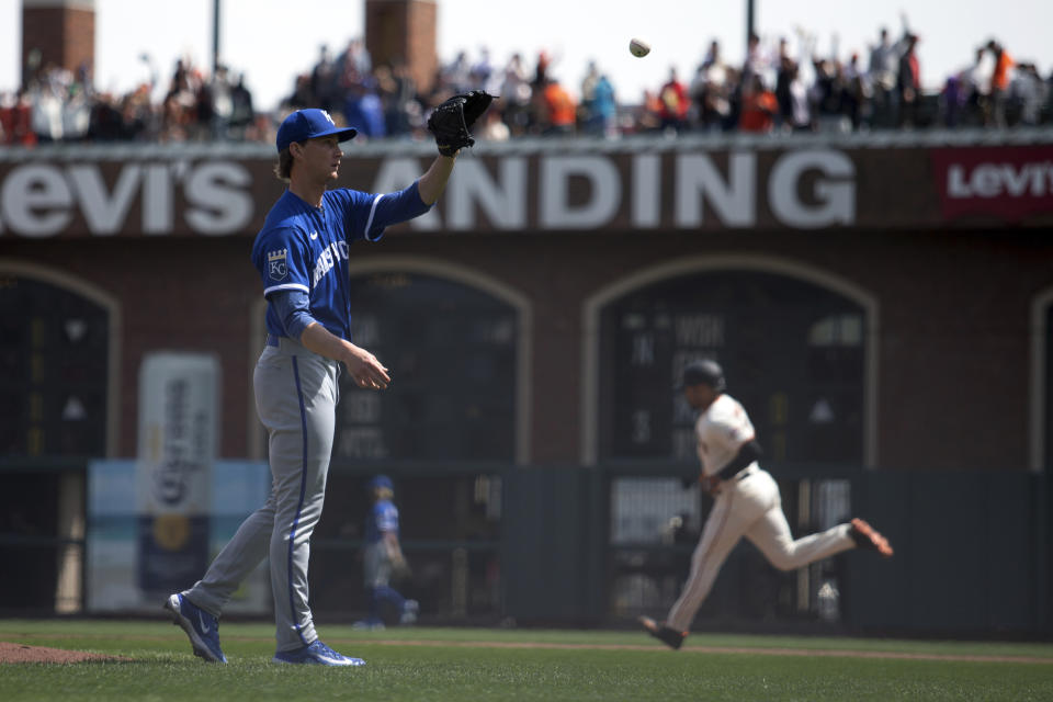 Kansas City Royals starting pitcher Brady Singer, left, gets a new ball as San Francisco Giants' LaMonte Wade Jr., right, runs out a solo home run during the fourth inning of a baseball game, Saturday, April 8, 2023, in San Francisco. (AP Photo/D. Ross Cameron)