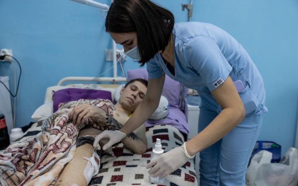 Nurse Alana Kulychenko checks the wounds of Yaroslav, 21, injured by a landmine in Kharkiv - Heathcliff O'Malley