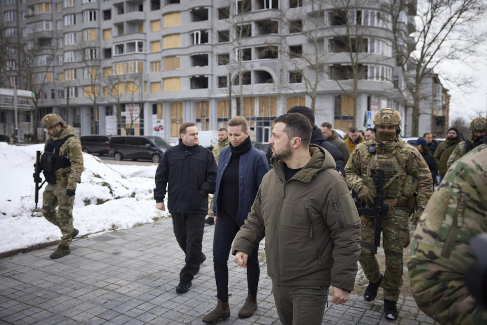 In this photo provided by the Ukrainian Presidential Press Office, Danish Prime Minister Mette Frederiksen, center, and Ukrainian President Volodymyr Zelenskyy watch the site of the recent Russian shelling in Mykolaiv, Ukraine, Monday, Jan. 30, 2023. (Ukrainian Presidential Press Office via AP)