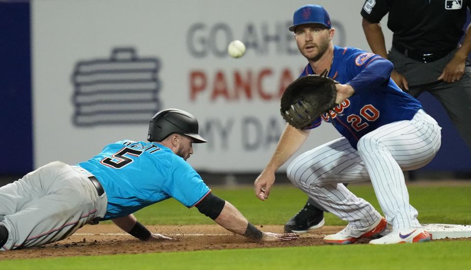 Mets first baseman Pete Alonso fields a pickoff attempt as the Marlins' Jon Berti dives back to the (new, larger) bag in a spring training game in Port St. Lucie, Fla.