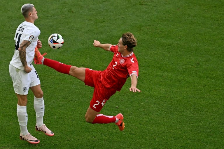 El defensa danés Joachim Andersen (de rojo) y el delantero esloveno Benjamin Sesko luchan por un balón en el partido del Grupp C de la Eurocopa que enfrentó a ambos países, en el Stuttgart Arena el 16 de junio de 2024 (Fabrice COFFRINI)