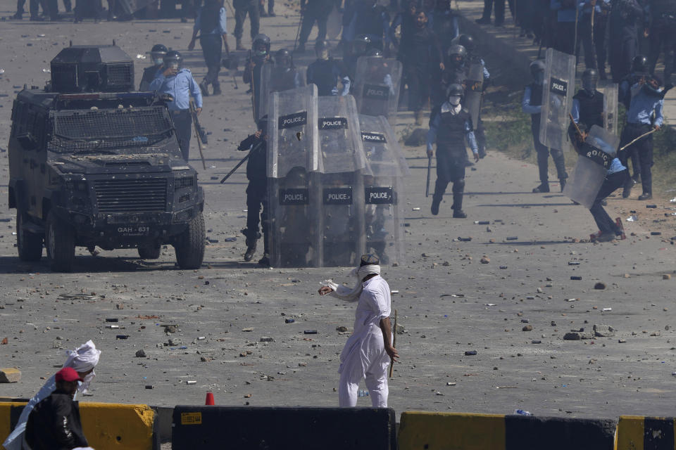 Police officers and supporters of Pakistan's former Prime Minister Imran Khan exchange stones during clashes, in Islamabad, Pakistan, Wednesday, May 10, 2023. A court has ruled that former Pakistani Prime Minister Imran Khan can be held for questioning for eight days. The decision Wednesday comes a day after the country’s popular opposition leader was dragged from a courtroom and arrested. His detention set off clashes between his supporters and police Tuesday. (AP Photo/Anjum Naveed)