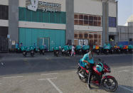 Delivery drivers for the app Deliveroo wait for orders, in Dubai, United Arab Emirates, Thursday, Sept. 9, 2021. Advocates and workers say that casualties among food delivery riders are mounting in the city of Dubai, as the pandemic accelerates a boom in customer demand. The trend has transformed Dubai’s streets and drawn thousands of desperate riders, predominantly Pakistanis, into the high-risk, lightly regulated and sometimes-fatal work. (AP Photo/Jon Gambrell)