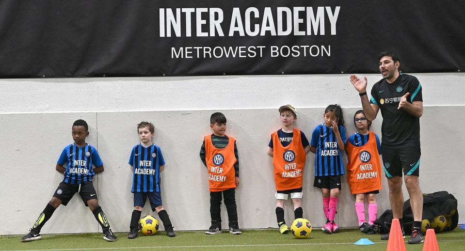 Luigi Mainolfi, far right, a coach from an elite youth soccer academy affiliated with Futbol Club Internazionale Milano in Milan, Italy, works with a group of youth soccer players during an Inter Academy Metro West Boston practice at SMOC's Community and Cultural Center in Framingham, April 6, 2022. Mainolfi will be in Framingham for two weeks to train local Academy MetroWest Boston coaches and work with youth soccer players in MetroWest.