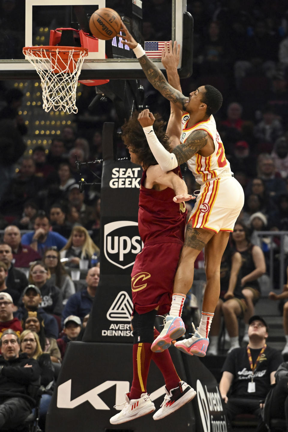 Atlanta Hawks forward John Collins attempts a dunk over Cleveland Cavaliers center Robin Lopez during the first half of an NBA basketball game, Monday, Nov. 21, 2022, in Cleveland. (AP Photo/Nick Cammett)