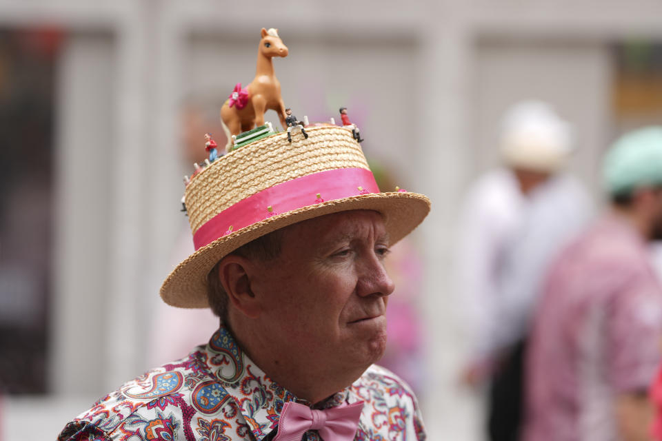 A race fan walks through the grounds of Churchill Downs before the 150th running of the Kentucky Oaks horse race Friday, May 3, 2024, in Louisville, Ky. (AP Photo/Abbie Parr)