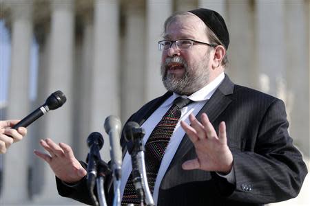 Rabbi Binyomin Ginsberg talks to reporters about his case, in which he sued Northwest Airlines for breach of contract after the airline said he had abused their frequent flyer program, after it was argued before the Supreme Court in Washington December 3, 2013. REUTERS/Jonathan Ernst