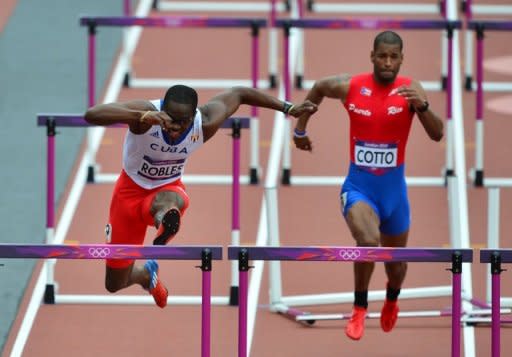 El cubano Dayron Robles (I) y el puertorriqueño Héctor Cotto compiten en 110m vallas en prueba de los Juegos de Londres-2012, el 7 de agosto de 2012. (AFP | gabriel bouys)