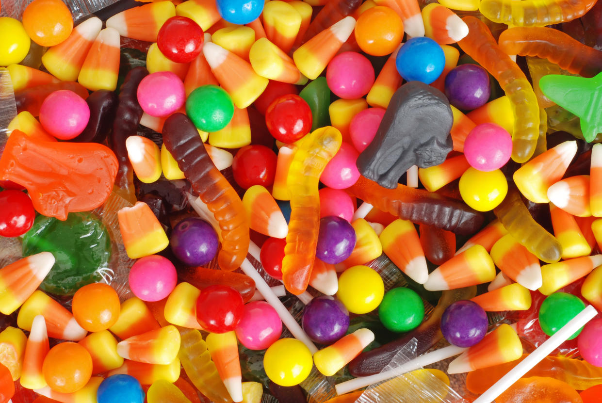 a pile of halloween candy, including candy corn, gummy worms, gum balls and jubes