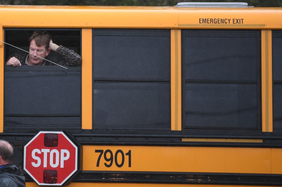 A man looks out of a school bus.&nbsp;