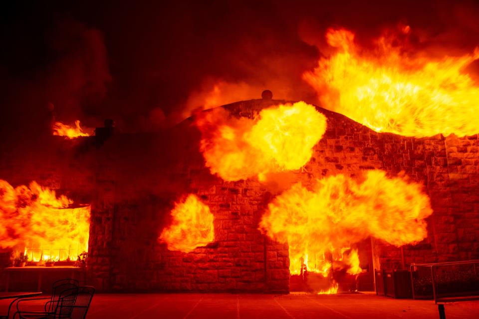 Fire explodes out the entrance of the Soda Rock Winery as it burns during the Kincade fire as flames race through Healdsburg, California on October 27, 2019. - Powerful winds were fanning wildfires in northern California in "potentially historic fire" conditions, authorities said October 27, as tens of thousands of people were ordered to evacuate and sweeping power cuts began in the US state. (Photo by Josh Edelson / AFP) (Photo by JOSH EDELSON/AFP via Getty Images)