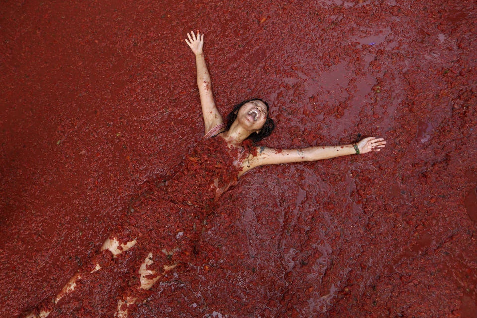 A woman reacts during the annual tomato fight fiesta called "Tomatina" in the village of Bunol near Valencia, Spain, Wednesday, Aug. 30, 2023. (AP Photo/Alberto Saiz)