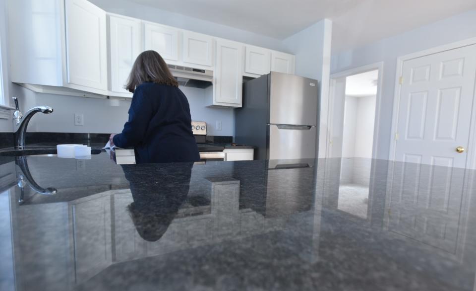 Habitat for Humanity of Cape Cod President and CEO Wendy Cullinan puts a shine on the granite kitchen countertops of a three-bedroom home on Murray Lane in West Harwich, part of a new Habitat for Humanity housing development.