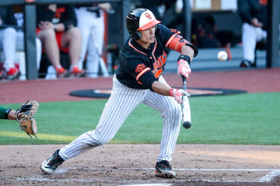 Oklahoma State catcher Chase Adkison (33) bunts during a college baseball game between the Oklahoma State Cowboys (OSU) and the Baylor Bears at O’Brate Stadium in Stillwater, Okla., on Saturday, March 25, 2023.