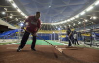 FILE - In this April 1, 2017, file photo, ground crew works on the bullpen behind the outfield wall at Olympic Stadium in Montreal. Starved for fans despite success on the field, the Tampa Bay Rays have been given the go-ahead by Major League Baseball to look into playing a split season in Montreal. No timetable for the possible plan was announced. An idea under consideration is for the Rays to play early in the season in Tampa Bay and later in Montreal. (Paul Chiasson/The Canadian Press via AP, File)