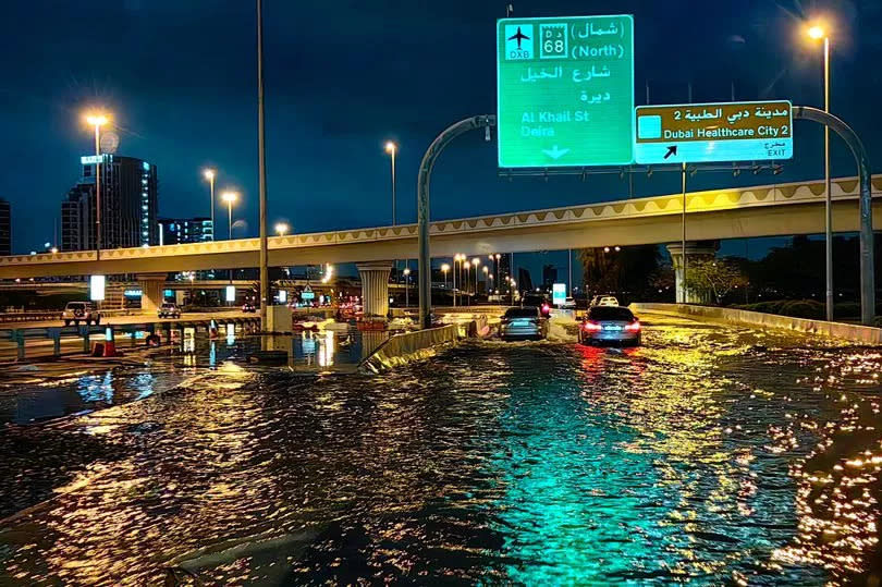 Motorisits drive along a flooded street following heavy rains in Dubai.