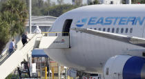 Passengers that came off the cruise ship Rotterdam Thursday, board a charter plane at Fort Lauderdale–Hollywood International Airport, Friday, April 3, 2020, in Fort Lauderdale, Fla. The Zaandam and a sister ship sent to help it, the Rotterdam, were given permission to unload passengers at Port Everglades on Thursday, after days of negotiations with officials who feared it would divert resources from a region with a spike in virus cases. (AP Photo/Wilfredo Lee)