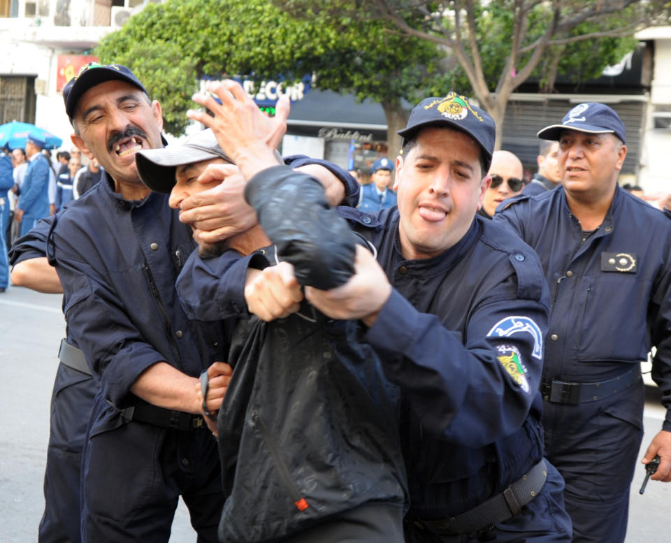 Algerian police officers detain an activist protesting against the president Abdelaziz Bouteflika running for a fourth term in Thursday's elections in Algier, Wednesday, April 16, 2014. President since 1999, Abdelaziz Bouteflika,77, is running for a 4th term despite being hit by a stroke last year that left him speaking and moving with difficulty. Six candidates are running for the powerful presidency in the April 17 elections. (AP Photo/Sidali Djarboub)