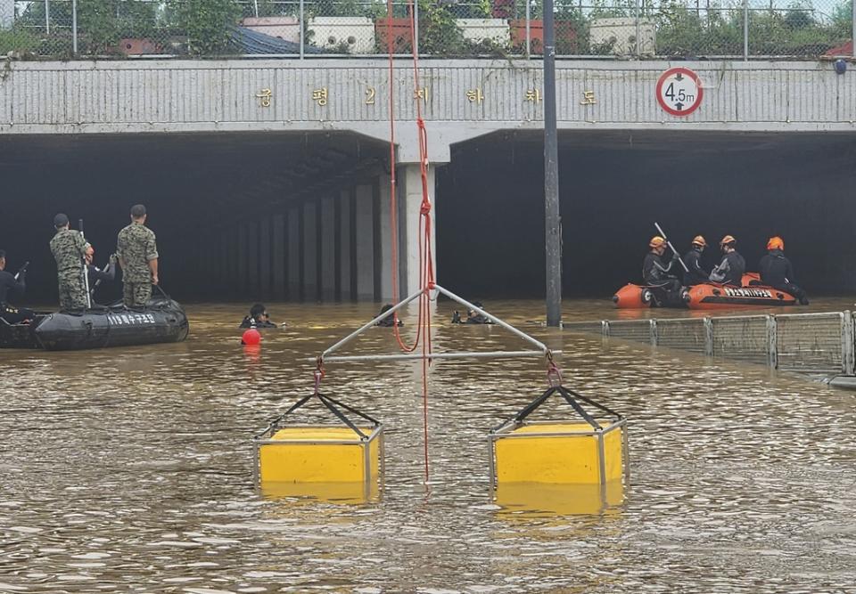 救援人員昨晚在忠清北道五松地下車道水浸現場，尋回最後一名失蹤者的遺體。（美聯社資料圖片）