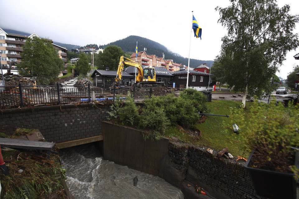 An excavator clears debris after the Susa river running through Are town following heavy rains in Are, northern Sweden, on Tuesday, Aug. 8, 2023. (Johan Axelsson/TT News Agency via AP)