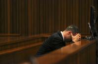 Olympic and Paralympic track star Oscar Pistorius reacts as he sits in the dock during his trial for the murder of his girlfriend Reeva Steenkamp at the North Gauteng High Court in Pretoria, March 17, 2014. Pistorius is on trial for murdering Steenkamp at his suburban Pretoria home on Valentine's Day last year. He says he mistook her for an intruder. REUTERS/Siphiwe Sibeko (SOUTH AFRICA - Tags: SPORT ATHLETICS CRIME LAW)