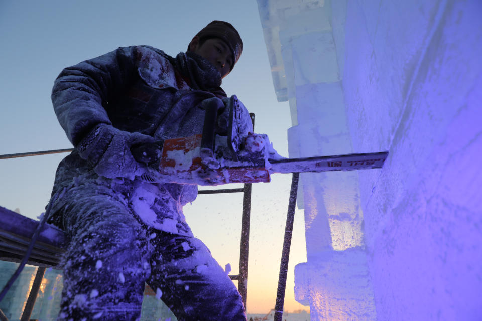 <p>A worker carves ice sculptures one day ahead of the opening of the 34th Harbin International Ice and Snow Festival on Jan. 4. (Photo: Wu Hong/EPA-EFE/REX/Shutterstock) </p>