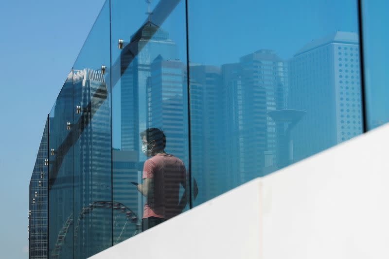 A man wears surgical mask walks through financial central district, following the outbreak of the new coronavirus, in Hong Kong