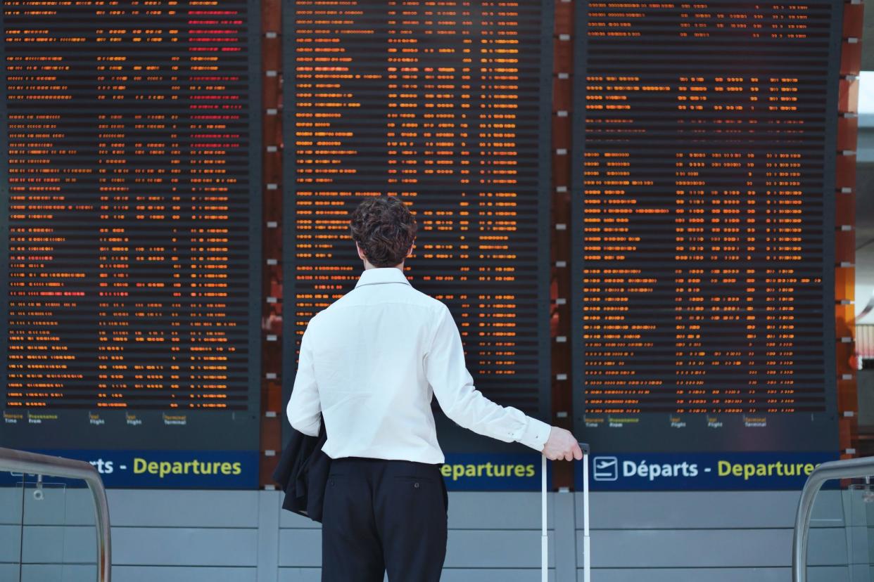 passenger looking at timetable board at the airport