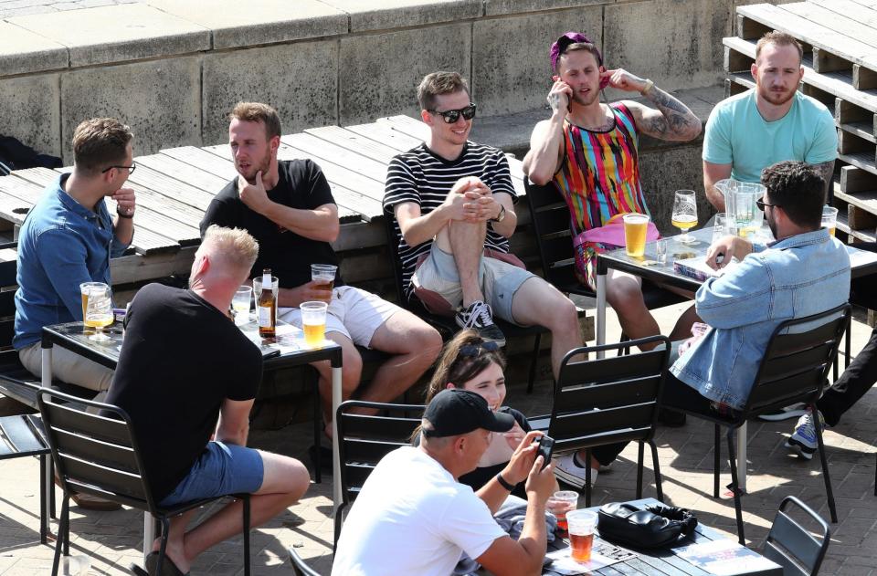 A group of friends enjoy the Autumn sunshine at a bar in Brighton: PA