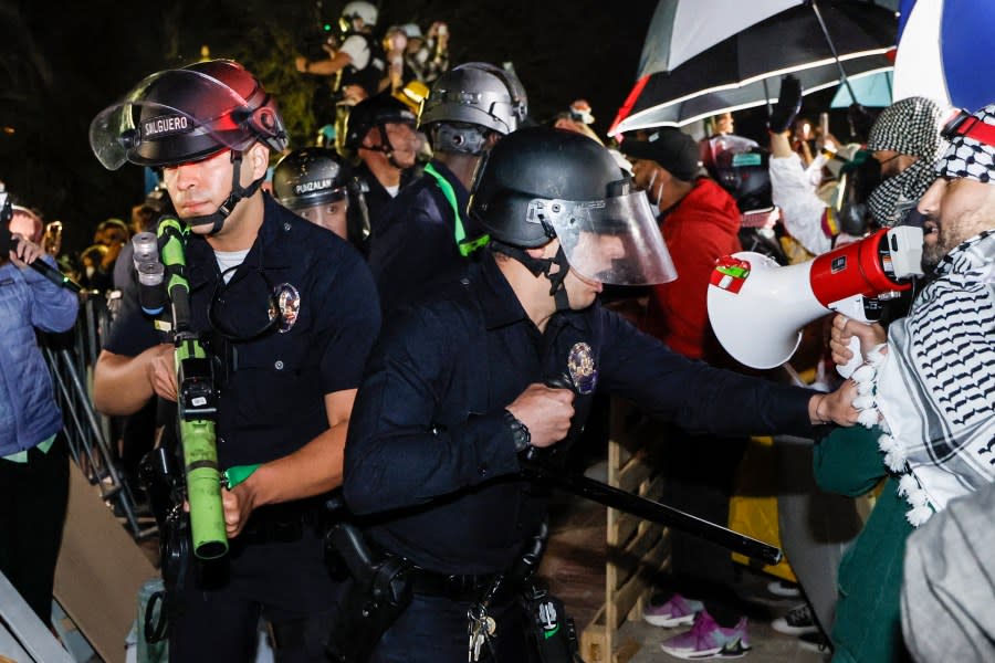 Police react while pro-Palestinian students stand their ground after police breached their encampment at the campus of the University of California, Los Angeles (UCLA) in Los Angeles, California, early on May 2, 2024. (Photo by ETIENNE LAURENT/AFP via Getty Images)