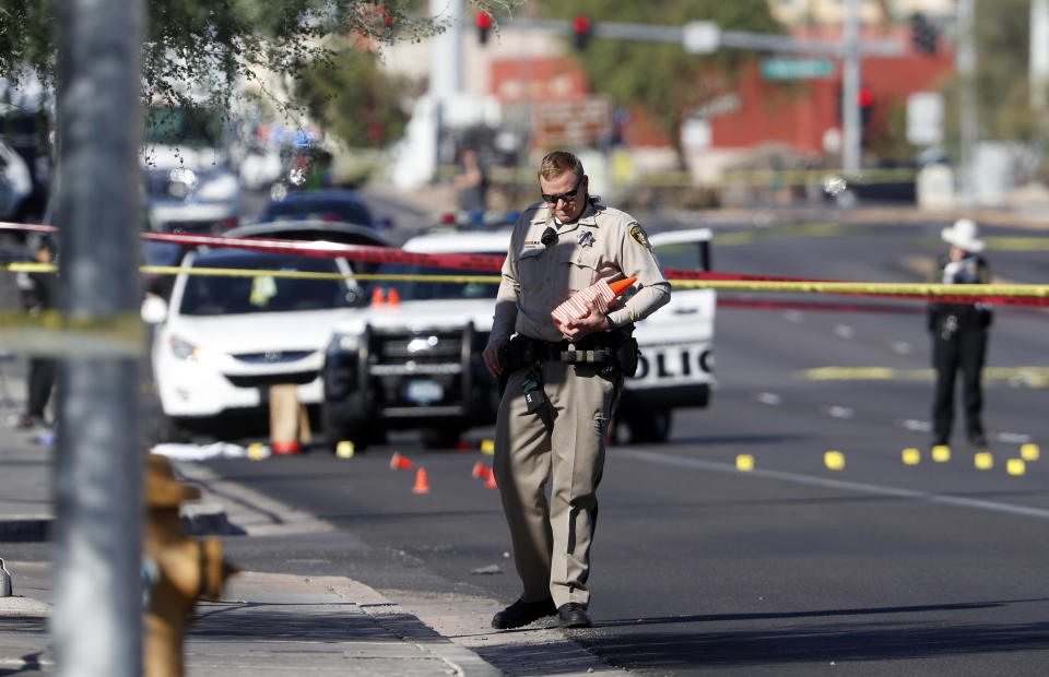 Las Vegas Metro Police and crime scene analysts work at the scene of fatal shooting in Las Vegas Thursday, Oct. 13, 2022. Clark County Sheriff Joe Lombardo told reporters that Officer Truong Thai was fatally wounded while he and another officer answering a 1 a.m. report of a domestic disturbance stopped a vehicle near a busy crossroads and the University of Nevada, Las Vegas, located east of the Las Vegas Strip.(Steve Marcus/Las Vegas Sun via AP)