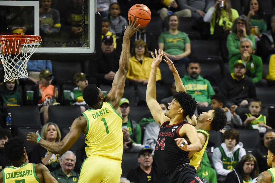 Oregon center N'Faly Dante (1) blocks a shot byStanford forward Spencer Jones (14) as Oregon guard Will Richardson, right, assists during the first half of an NCAA college basketball game Saturday, March 4, 2023, in Eugene, Ore. (AP Photo/Andy Nelson)