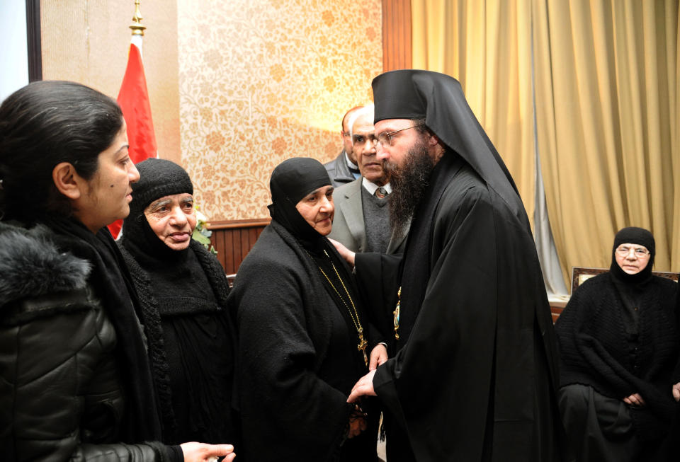 In this photo released by the Syrian official news agency SANA, a group of nuns who were freed after being held by Syrian rebels, greet church officials at the Syrian border town of Jdeidat Yabous, early Monday, March. 10, 2014. Rebels in Syria freed more than a dozen Greek Orthodox nuns on Monday, ending their three-month captivity in exchange for Syrian authorities releasing dozens of female prisoners. The release of the nuns and their helpers, 16 women in all, is a rare successful prisoner-exchange deal between Syrian government authorities and the rebels seeking to overthrow the rule of President Bashar Assad. (AP Photo/SANA)