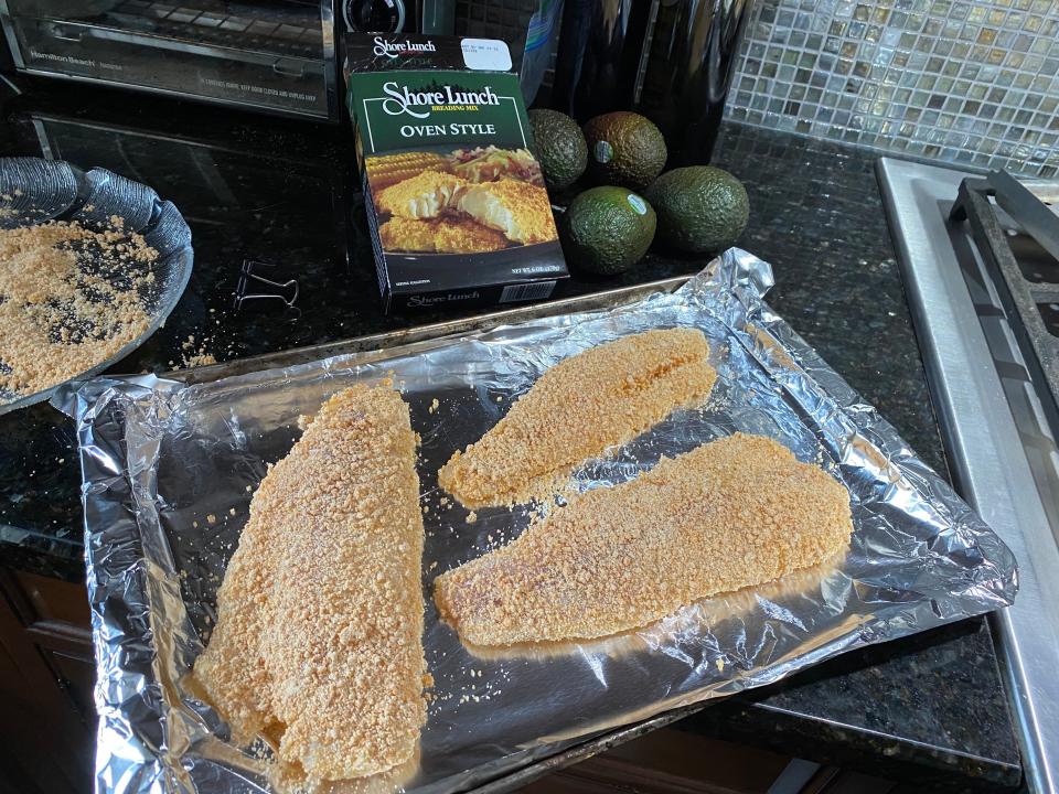 Largemouth bass filets coated in beaten egg and a seasoned breading are ready to be baked.