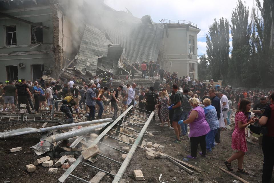 Emergency officials and civilians conduct search and rescue operations among the rubble of Okhmatdyt Children's Hospital