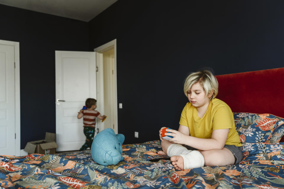 a kid playing with a rubik cube in their bedroom